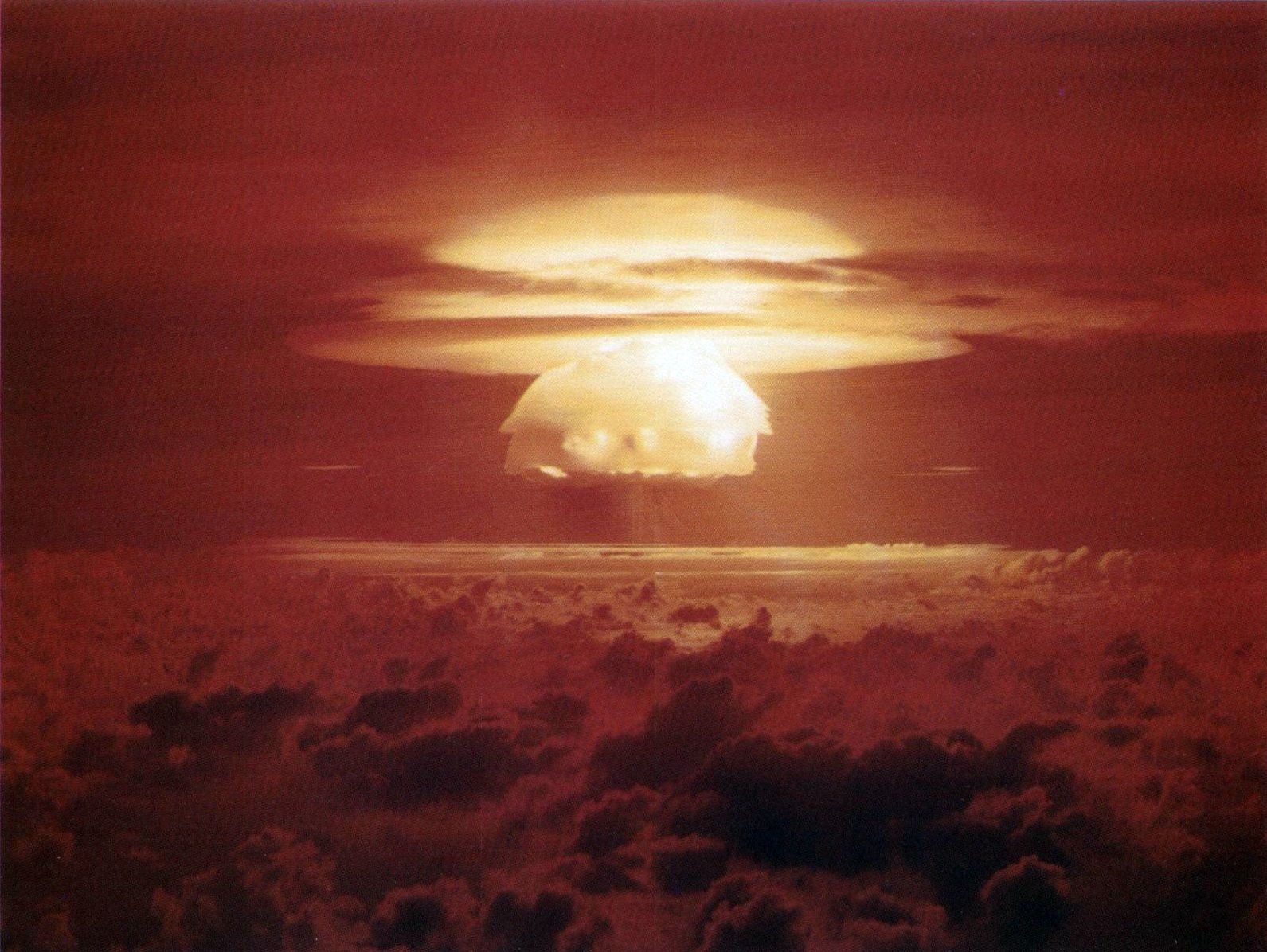 The fireball of Castle Bravo, the largest American nuclear test, rising through a red sky above the clouds over Bikini Atoll in March 1954.
